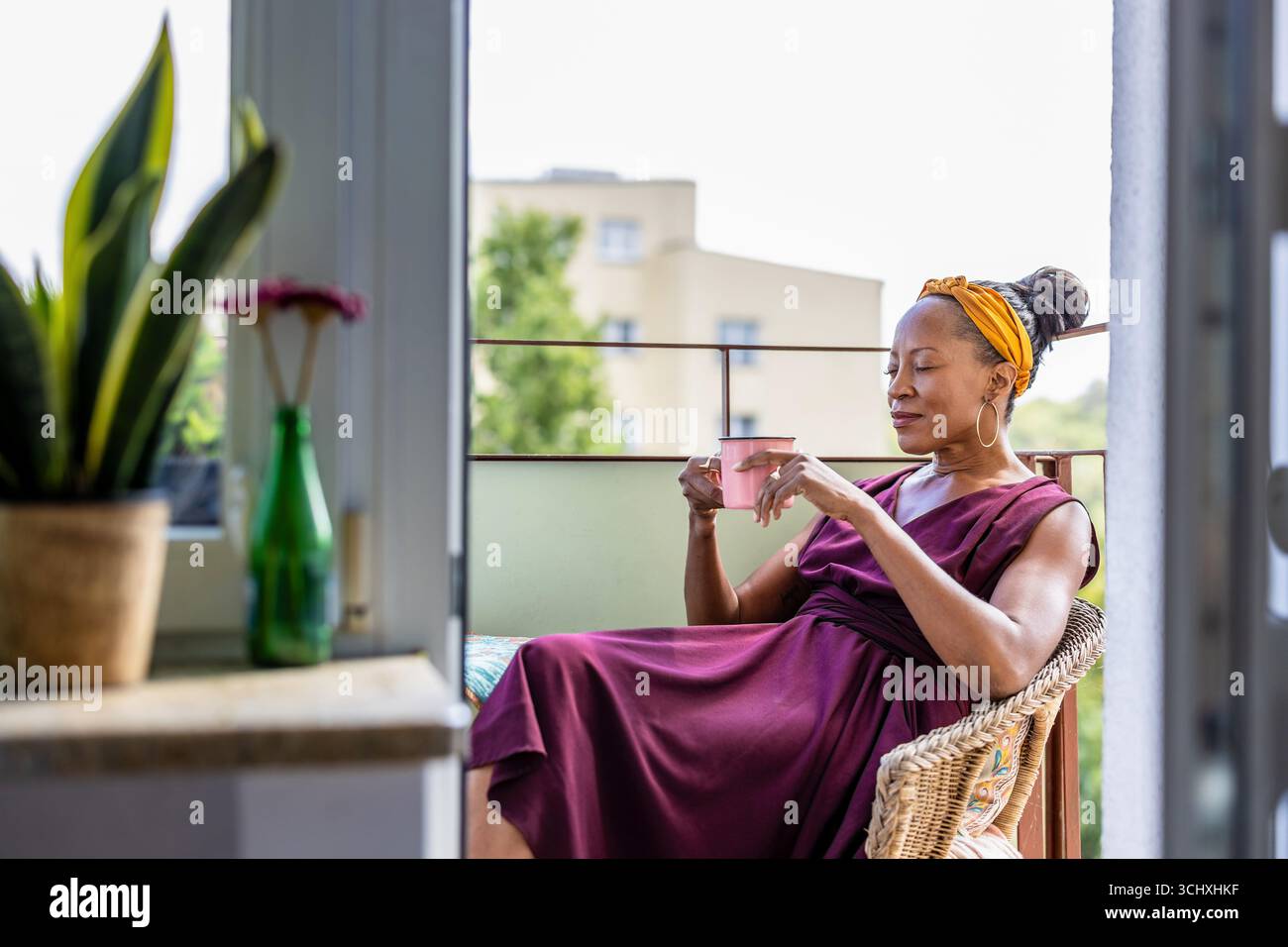 Woman drinking coffee at home balcony Stock Photo