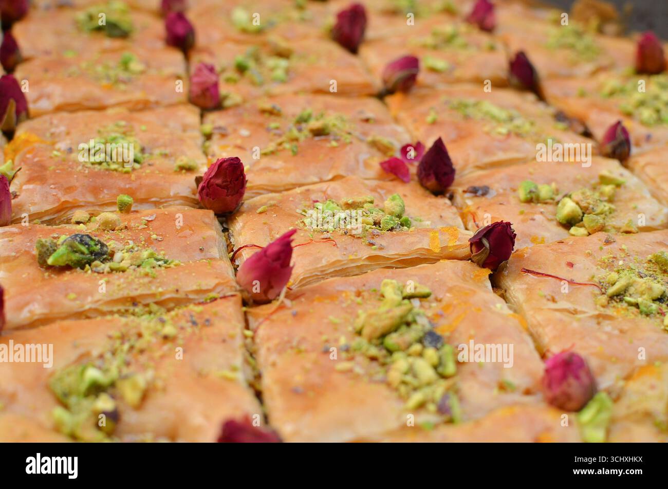 A detailed close-up of baklava pastry decorated with small rosebuds. Stock Photo