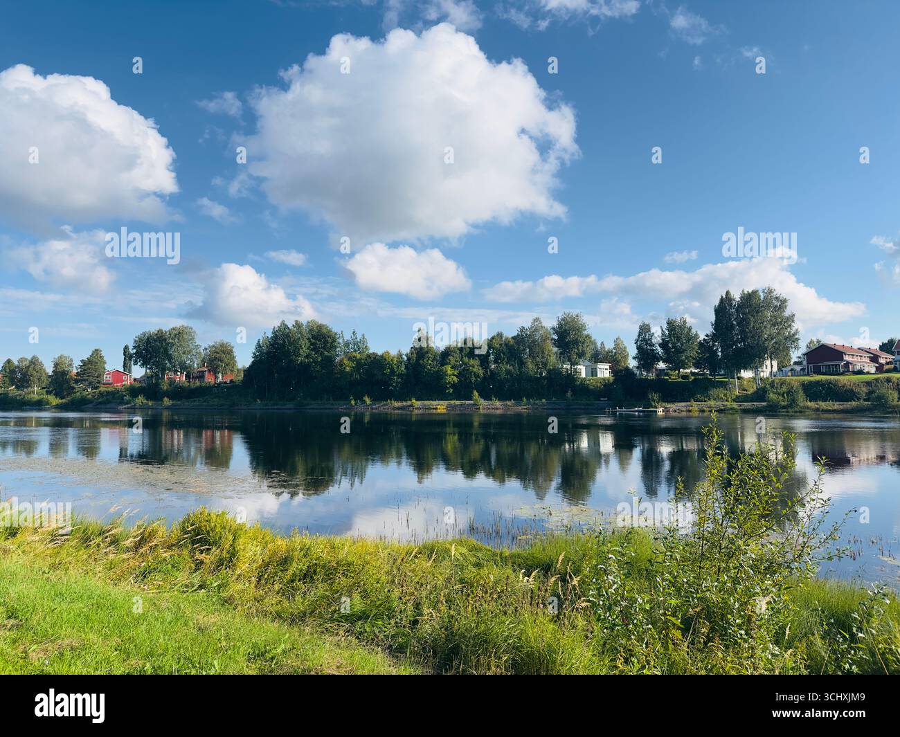 Scenic lake view with blue sky and fluffy clouds Stock Photo