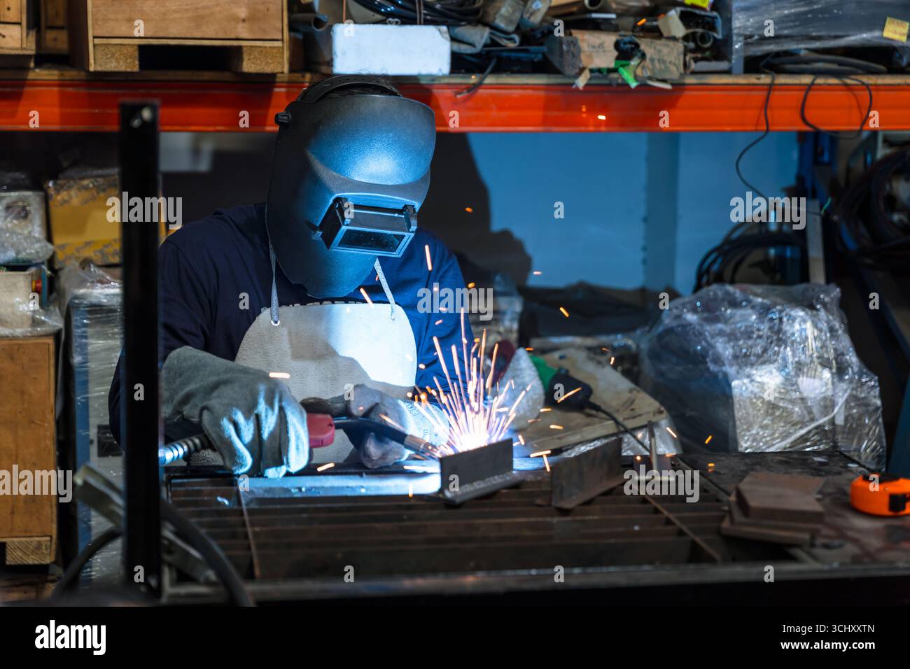 Engineer technician staff skill worker working manual metal parts welding in metal machinery workshop Stock Photo