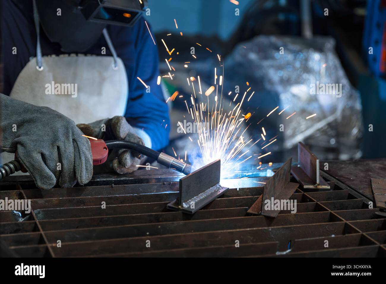 Engineer technician staff skill worker working manual metal parts welding in metal machinery workshop Stock Photo