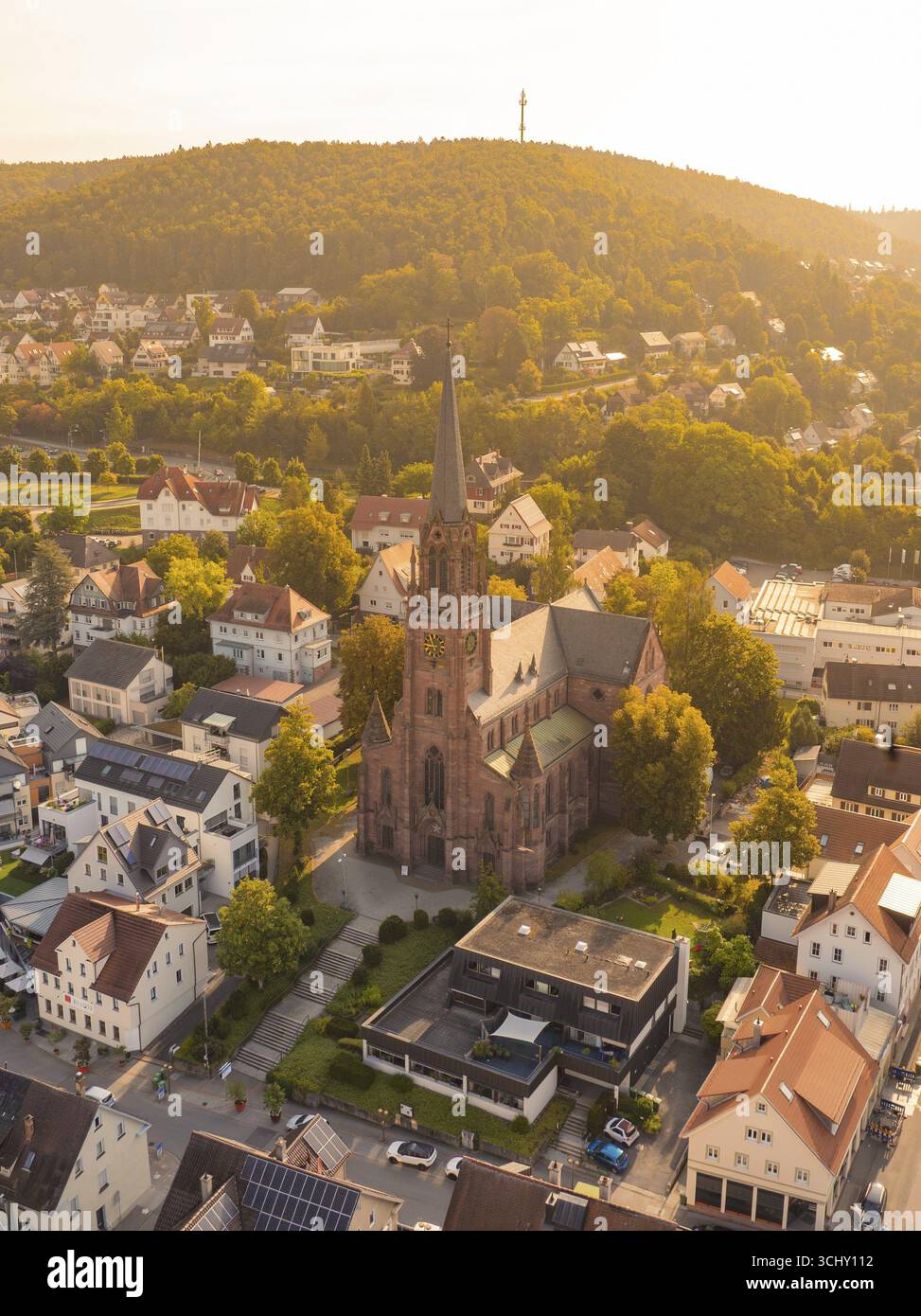 Church in the centre of a small town with a hill in the background, warm golden light envelops the town, small town pearl Nagold, Black Forest, German Stock Photo
