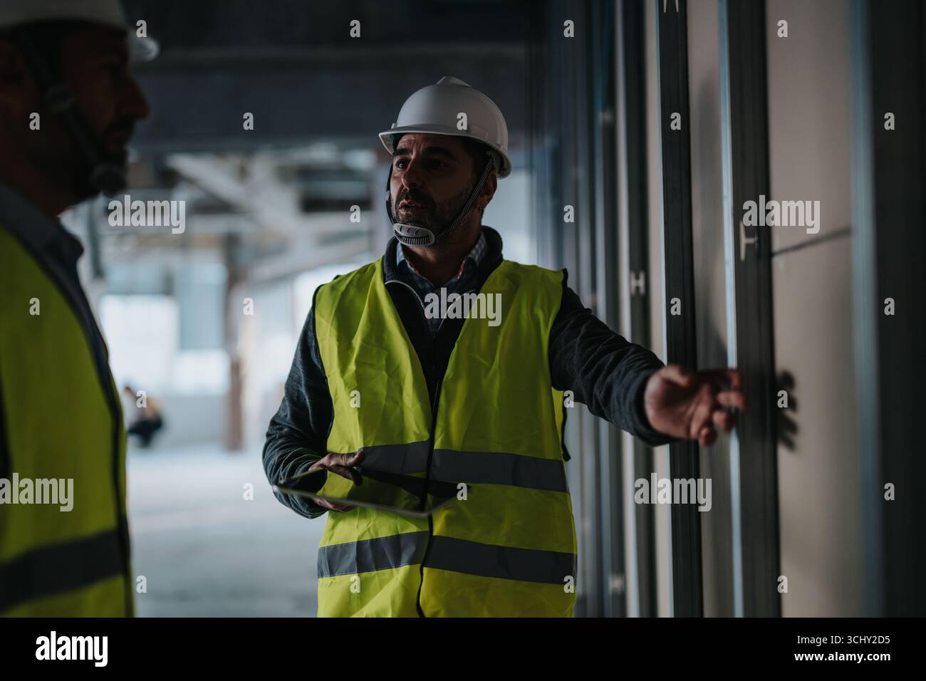 Construction professionals inspecting a job site and collaborating on site developments Stock Photo