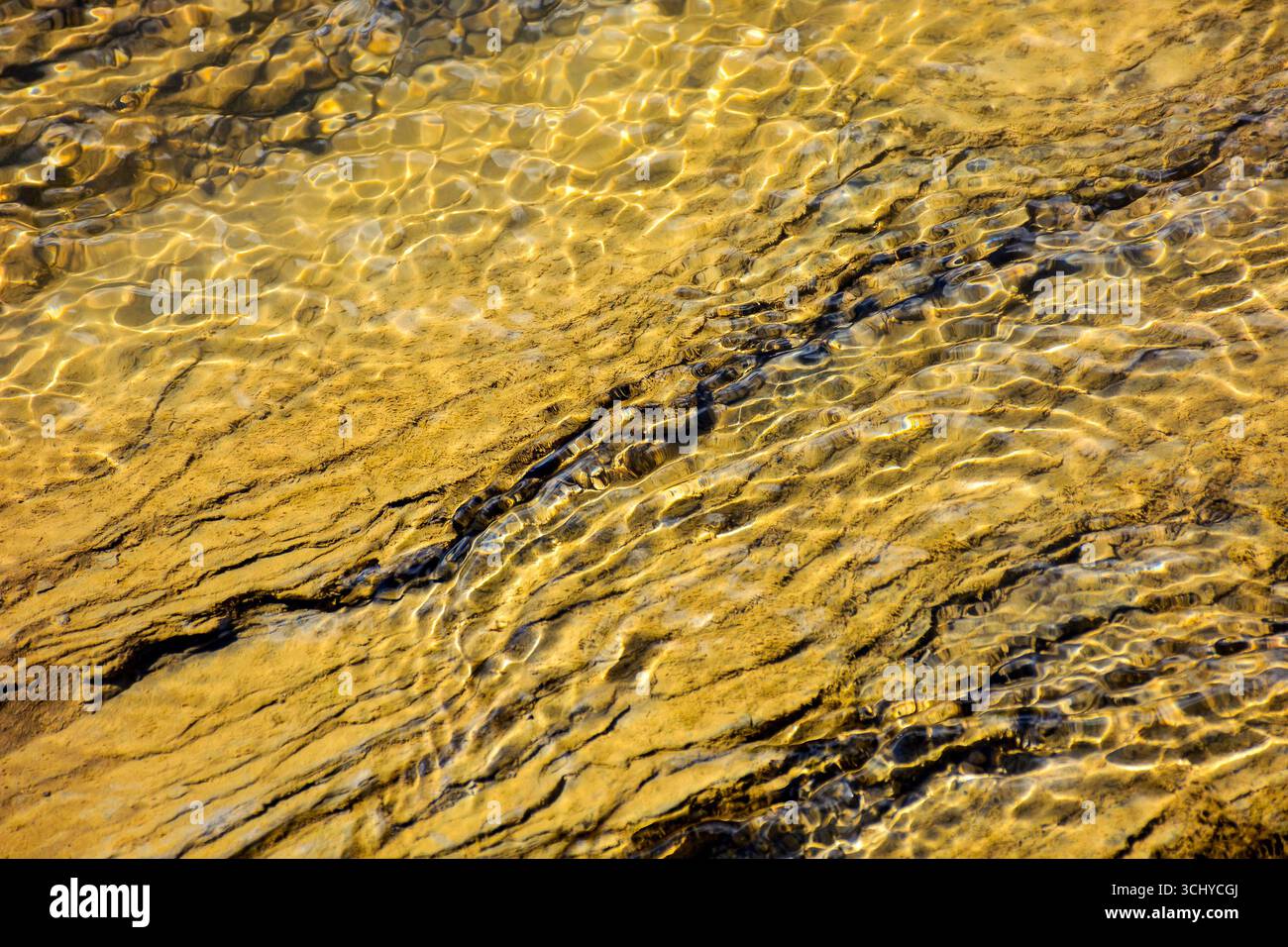 nature texture with stones in the water steam. closeup background of a river shore in autumn Stock Photo