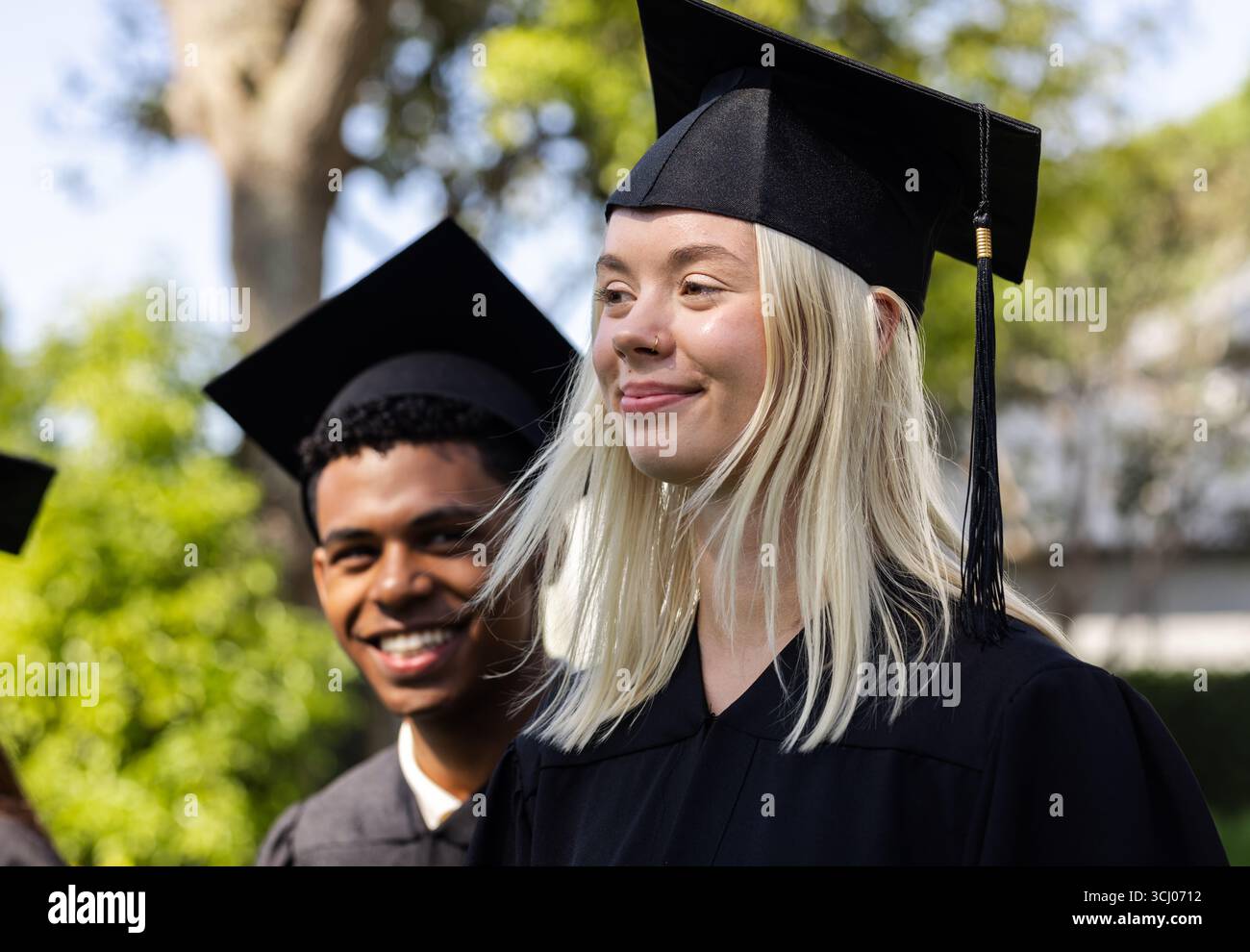 Celebrating graduation wearing gowns diverse hi-res stock photography ...