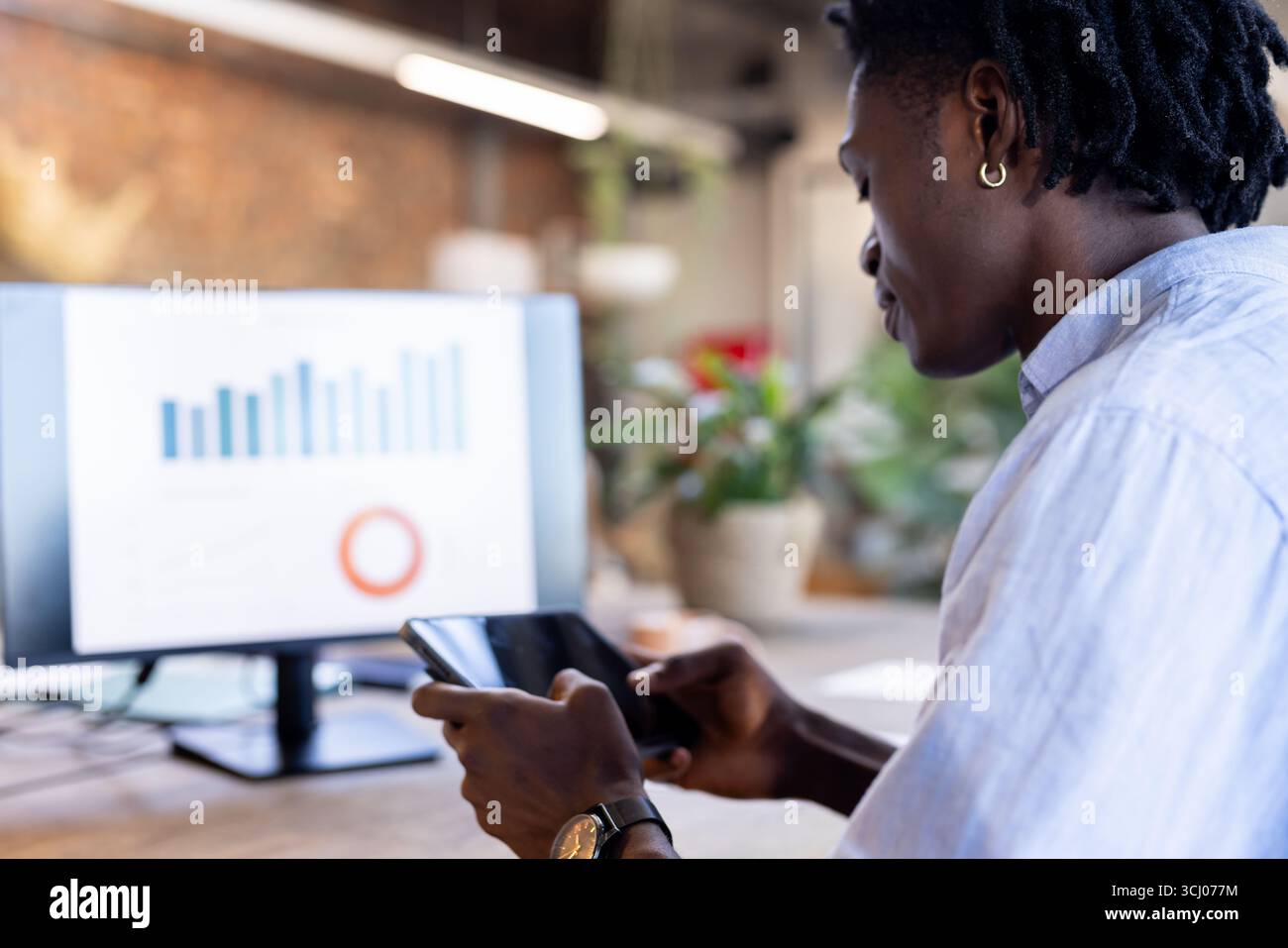 Business professional analyzing data on tablet and computer in modern office Stock Photo