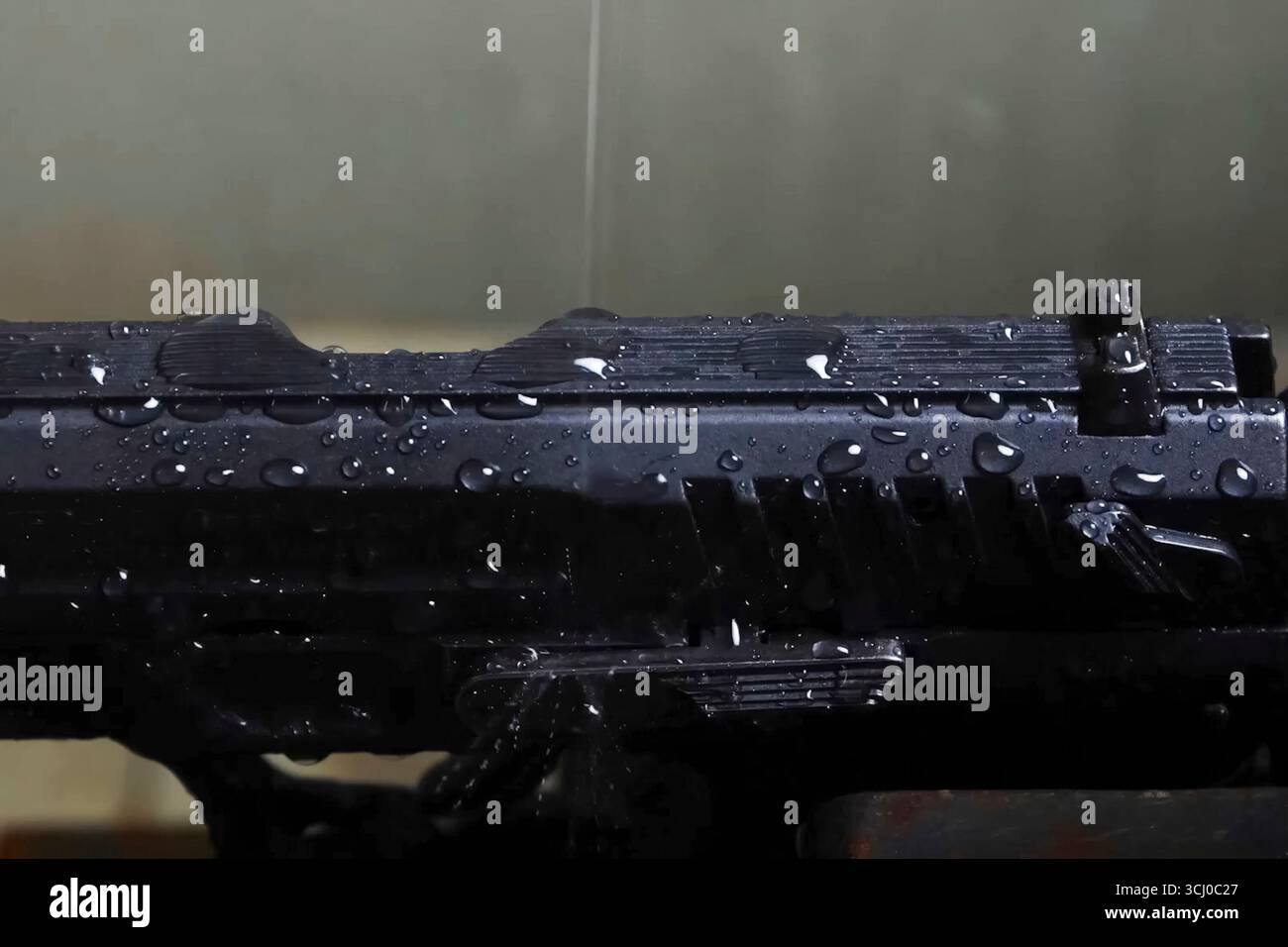 The body of the pistol is covered with droplets. Checking weapons in ...