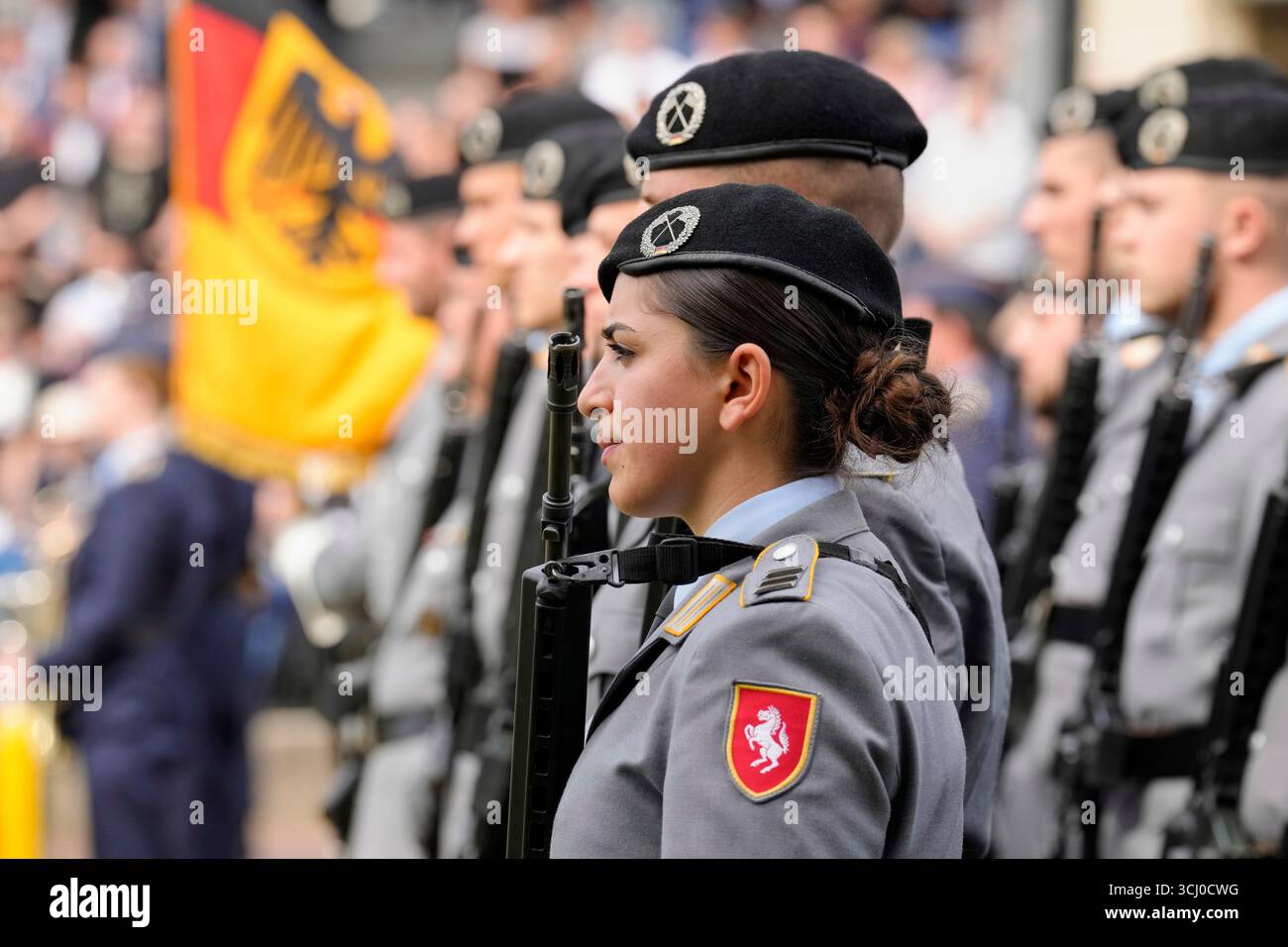 A female armed soldier watches new recruits of the German Army ...
