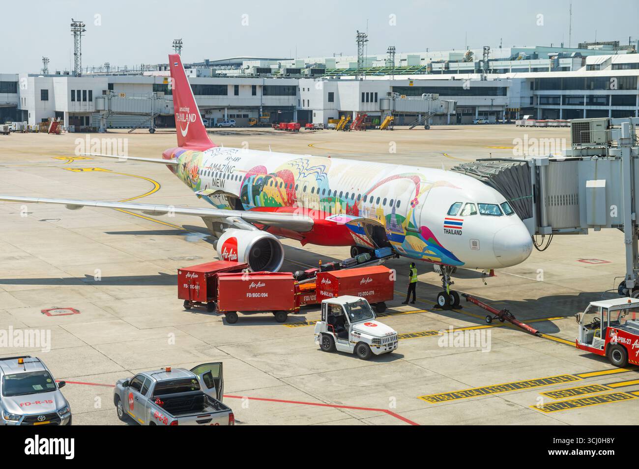 Bangkok, Thailand - March 10, 2025 : Colorful AirAsia airplane with promotional Amazing Thailand livery is parked at the gate at Don Mueang Stock Photo