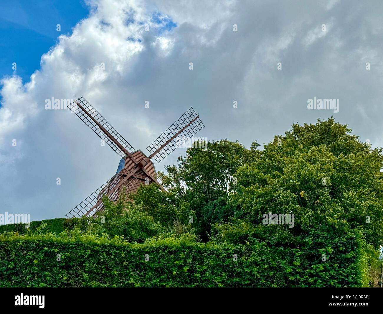 the verzenay windmill standing on top of a hill surrounded by trees and vineyards, cloudy sky, champagne region, France - Smartphone Captured Stock Image