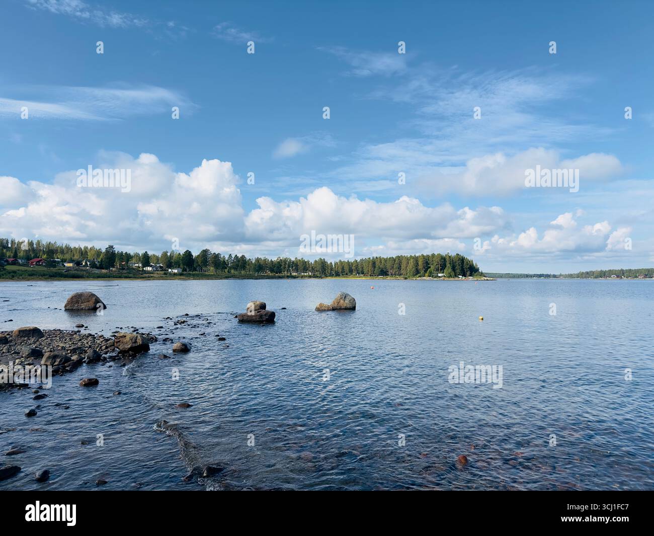 Serene coastal landscape featuring an island with lush trees under a clear blue sky. - Smartphone Captured Stock Image