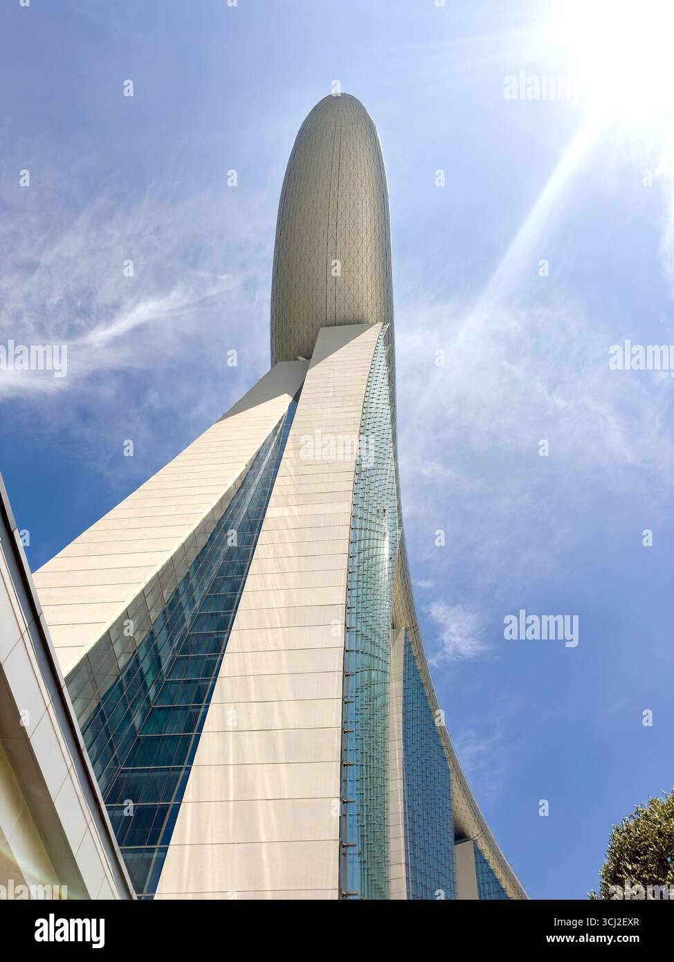 Low angle view of modern marina bay sands hotel skyscraper with a unique rooftop design against a blue sky with bright sunlight singapore - Smartphone Captured Stock Image