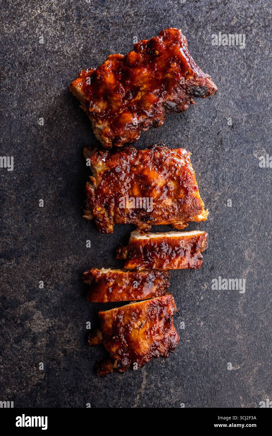 Pork BBQ glazed ribs on a black table. Top view. Stock Photo