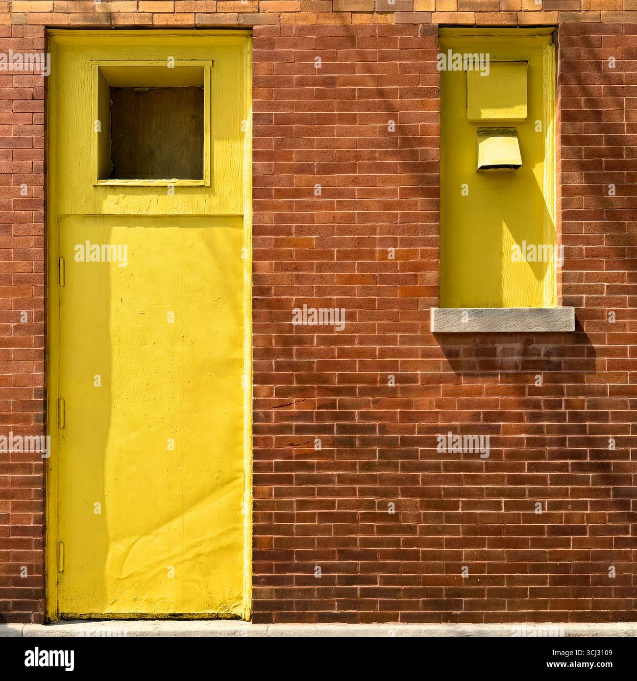 Industrial yellow painted warehouse door in plain red brick wall of Chicago building. - Smartphone Captured Stock Image