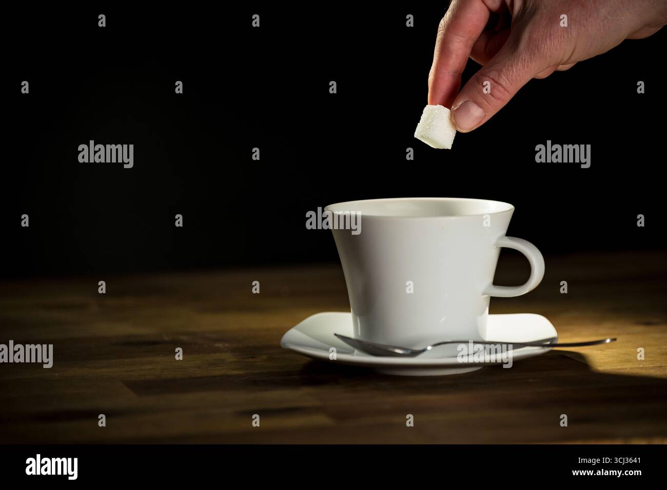 Adding sugar cube into the drink, risk of high blood pressure, obesity, inflammation, fatty liver and diabetes. Stock Photo