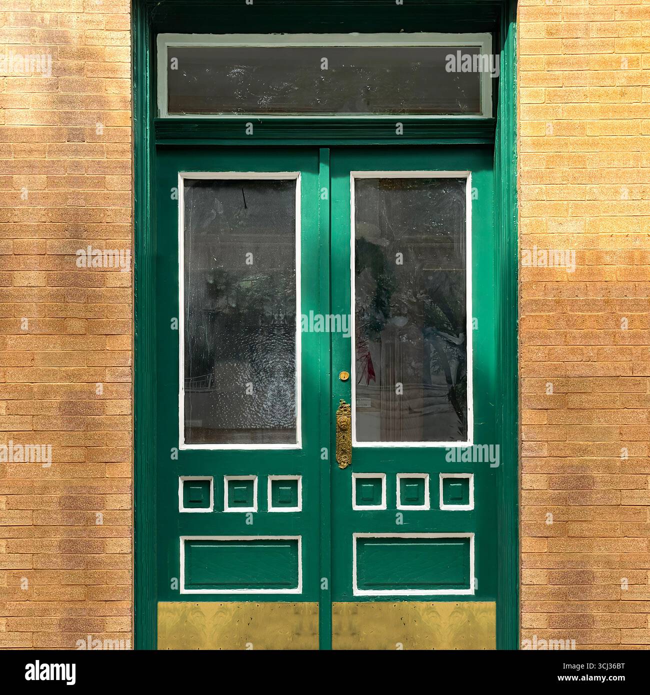 Elegant green door with brass accents and transom window set in a tan brick facade, Chicago historic architecture. - Smartphone Captured Stock Image
