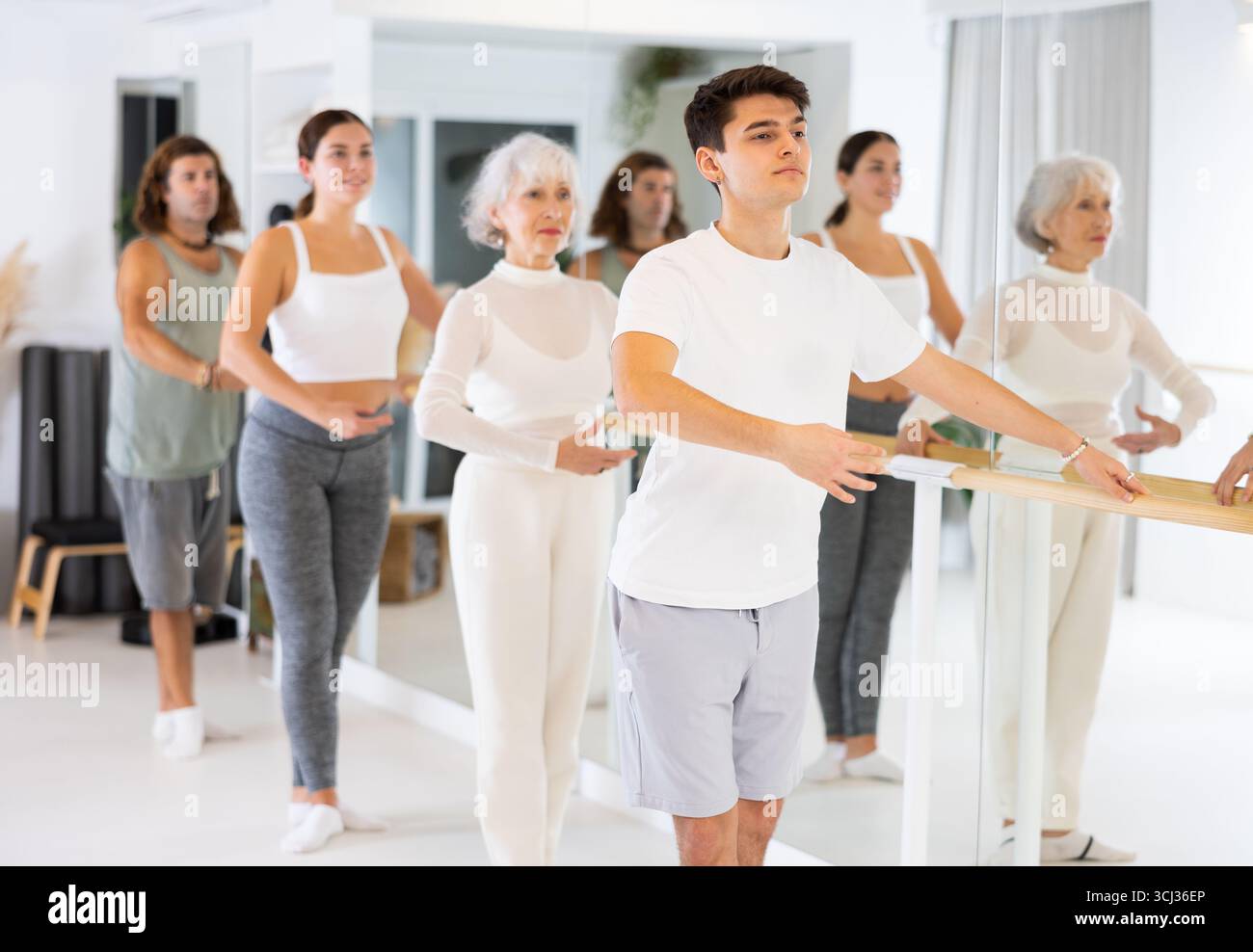 Diligent young man doing choreography at ballet barre Stock Photo