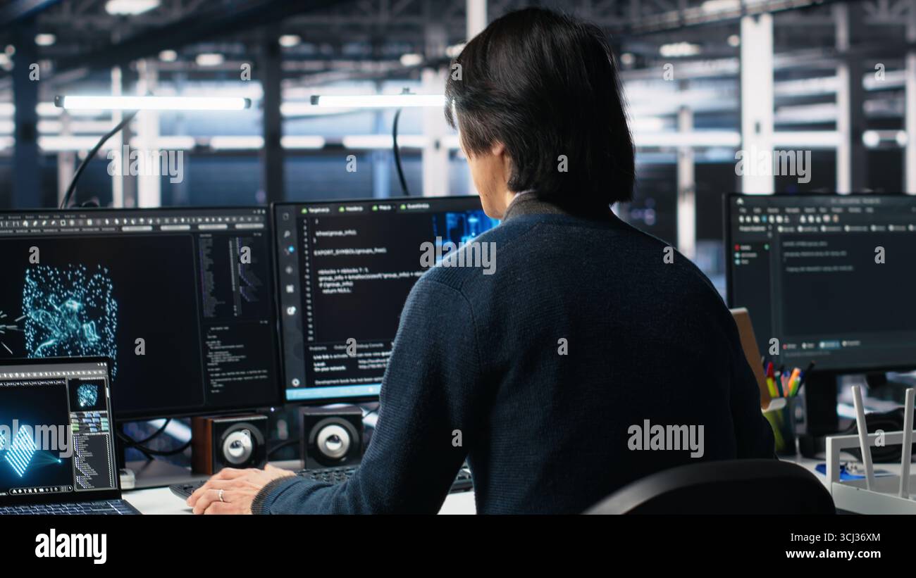 Software developer entering server room office, using AI to review infrastructure diagnostics. System administrator in data center analyzes performance data using artificial intelligence tech Stock Photo