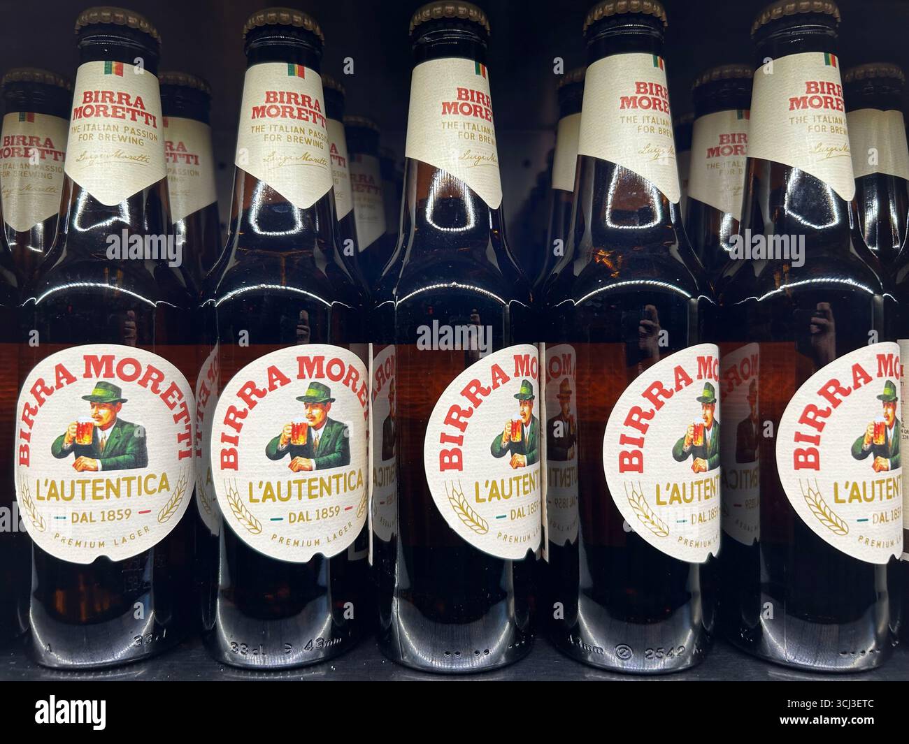 Rows of bottles of Birra Moretti L'Autentica Italian beer for sale - Smartphone Captured Stock Image