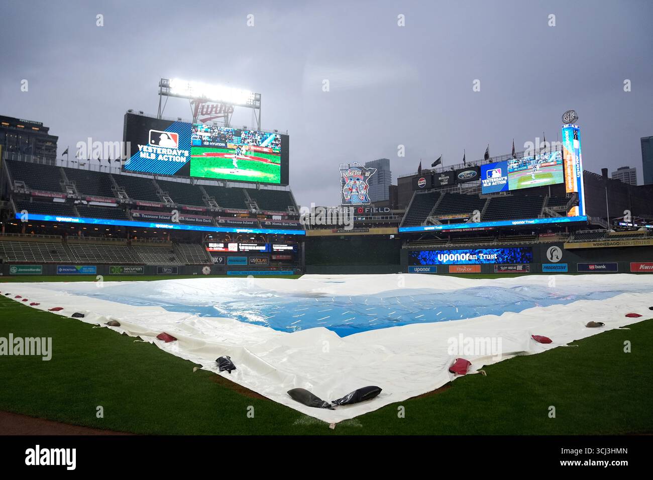 A tarp covers the infield before a baseball game between the Minnesota ...