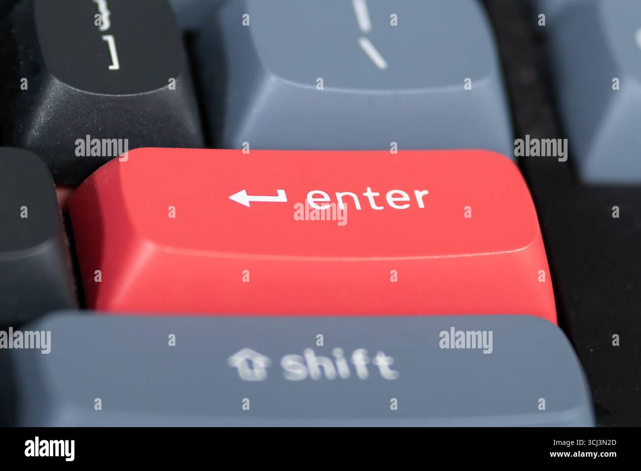 close up from a Red enter keyboard key with focus on the return key Stock Photo