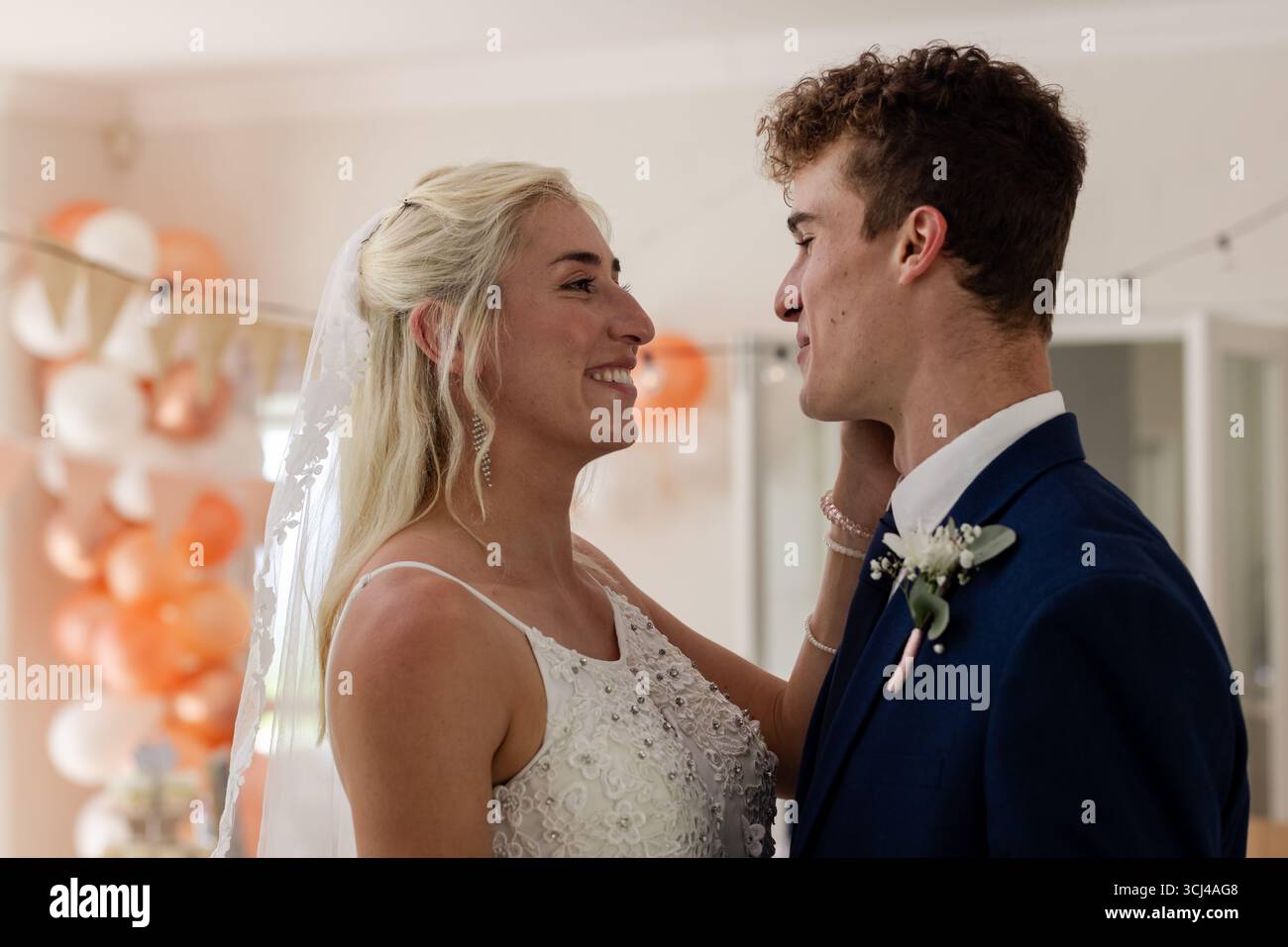 Bride and groom sharing joyful moment, smiling and embracing at wedding celebration Stock Photo