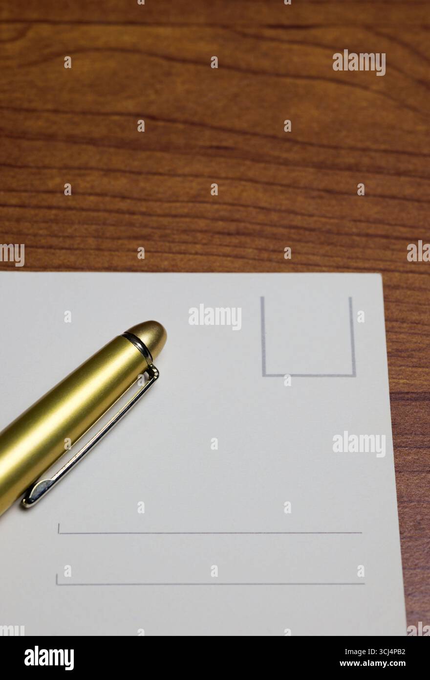 golden pen and postacrd on table Stock Photo
