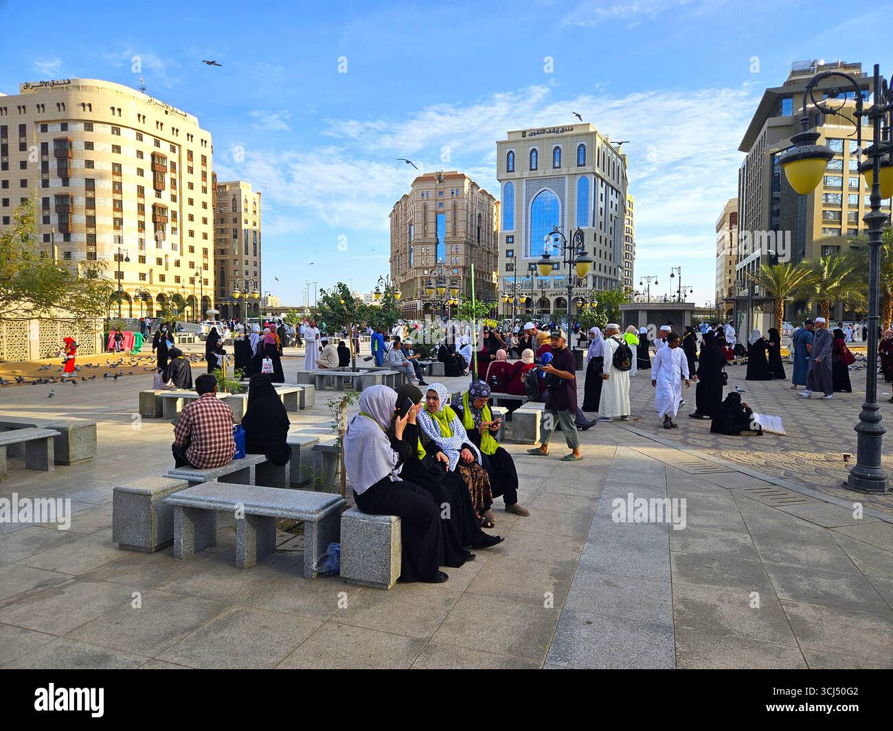 People in the city park enjoying the evening atmosphere. Madinah, Saudi Arabia - March 6th, 2024 - Smartphone Captured Stock Image