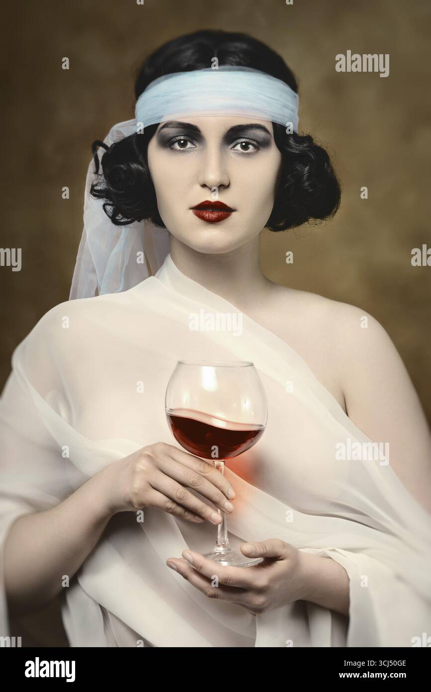 Young woman in antic modern vintage retro style with red wine looking at camera Stock Photo