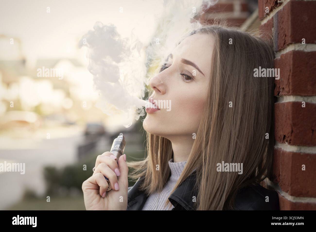 lady slim electronic cigarette young woman smoking electronic cigarette in the city Stock Photo