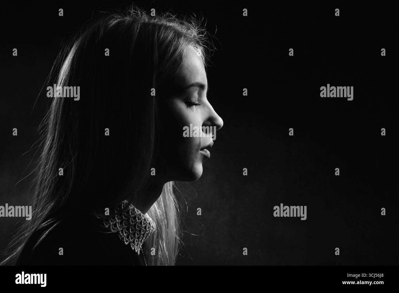 Sad girl crying on black background, monochrome Stock Photo - Alamy