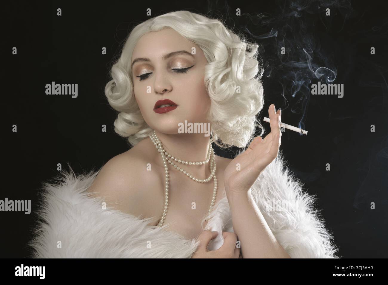 Luxury young woman smoking on black background Stock Photo - Alamy