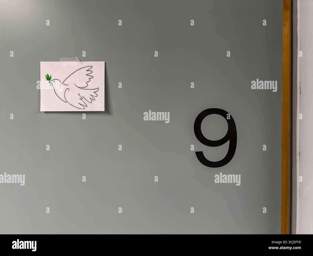 A (rather pixelated) printout of a dove of peace, taped to the door of a hospital room to indicate that the patient within has died. - Smartphone Captured Stock Image