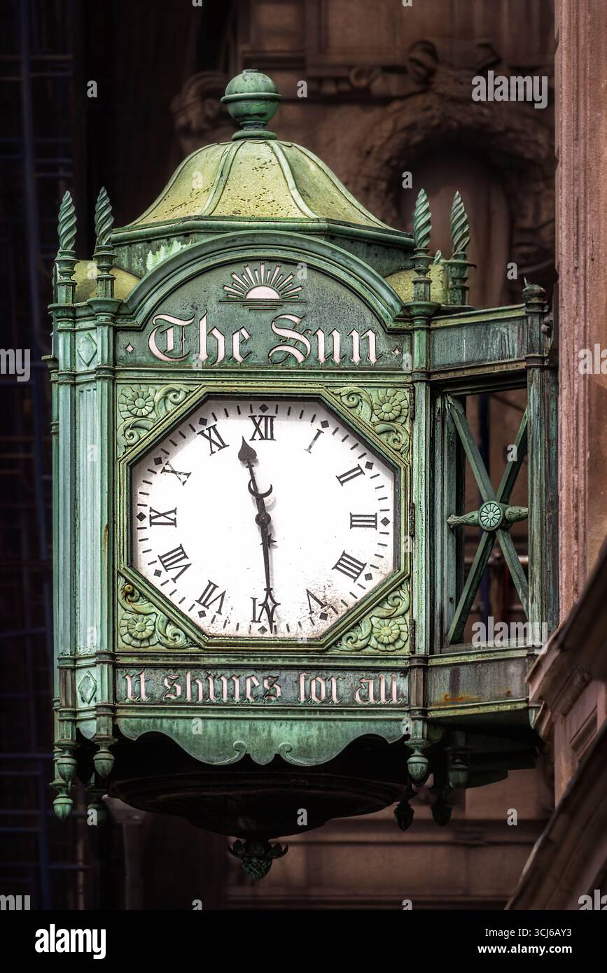 The New York Sun Clock - This close-up photograph captures the ornate, bronze, weathered green clock with "The Sun" inscribed at the top. Stock Photo