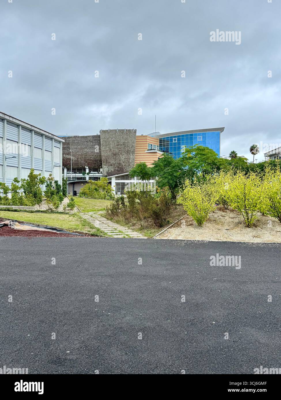 Green space at Escola Secundária Domingos Rebelo with Parque Atlântico shopping mall in the background, Ponta Delgada, Azores, Portugal. - Smartphone Captured Stock Image