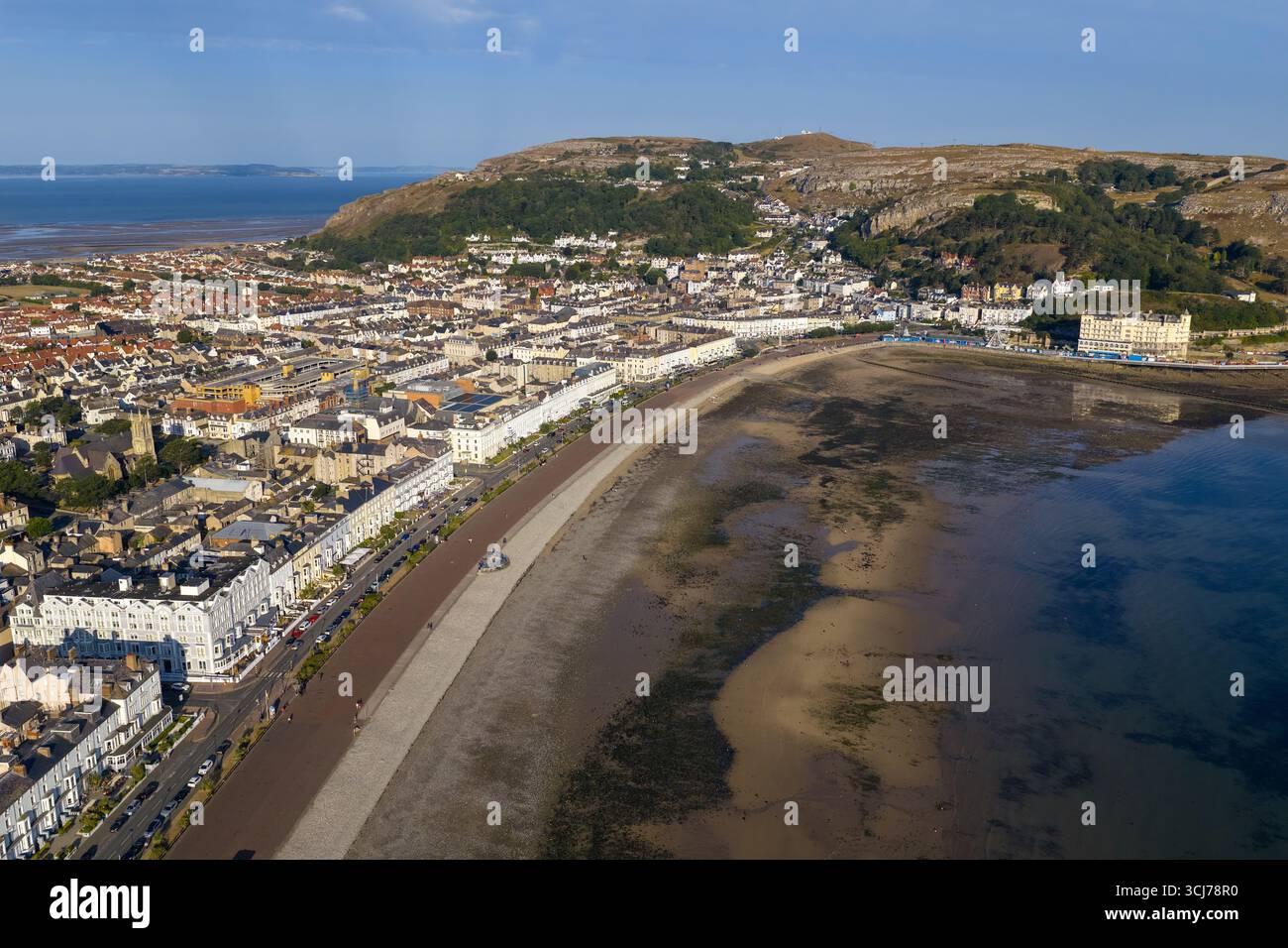Aerial image of Llandudno, Wales, featuring the sweeping curve of the promenade, and sandy beach at low tide. Stock Photo