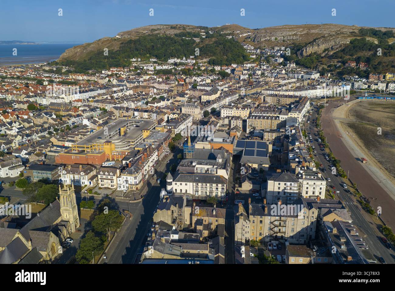 Aerial image of Llandudno, Wales, featuring the sweeping curve of the promenade, and sandy beach at low tide. Stock Photo
