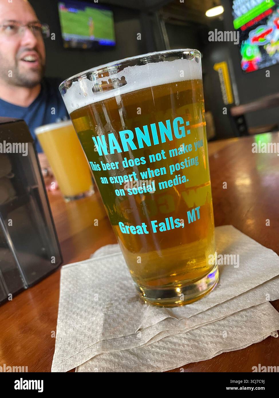 Still life of a funny beer glass with the warning that drinking beer does not make you an expert, 2025, Great Falls, Montana, United States - Smartphone Captured Stock Image