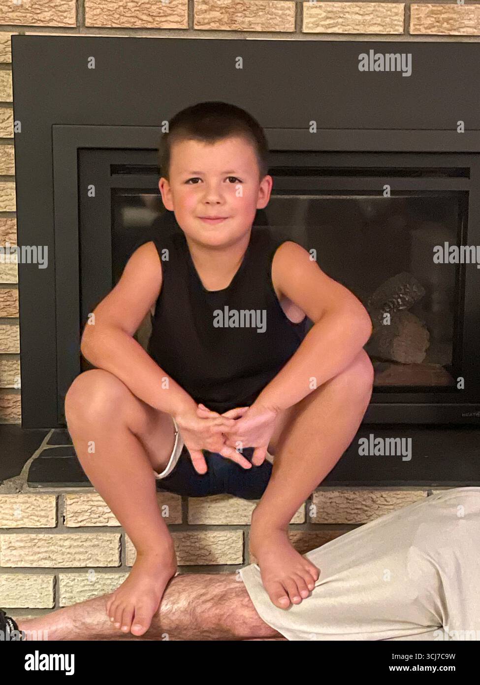 Self assured seven year-old stares at the camera n the living room of the residential house, 2025, Great Falls, MT, US - Smartphone Captured Stock Image