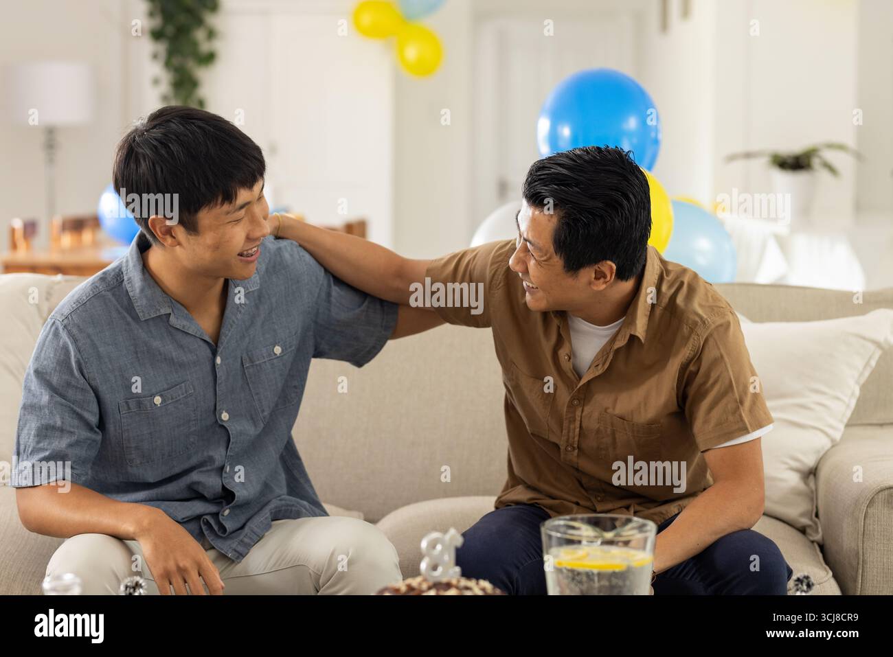 Two men sitting on sofa hi-res stock photography and images - Alamy
