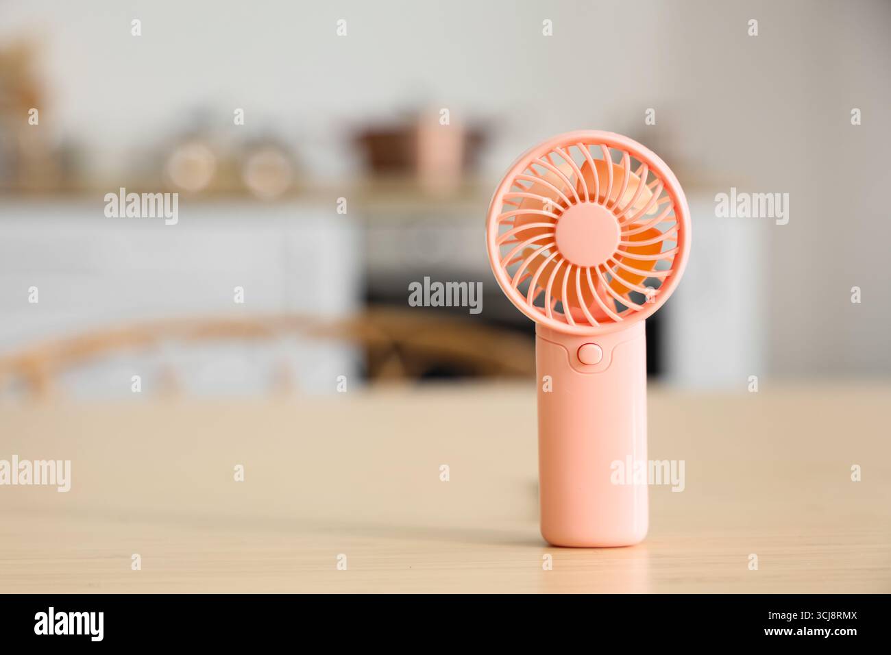 Mini fan on table in kitchen, closeup Stock Photo