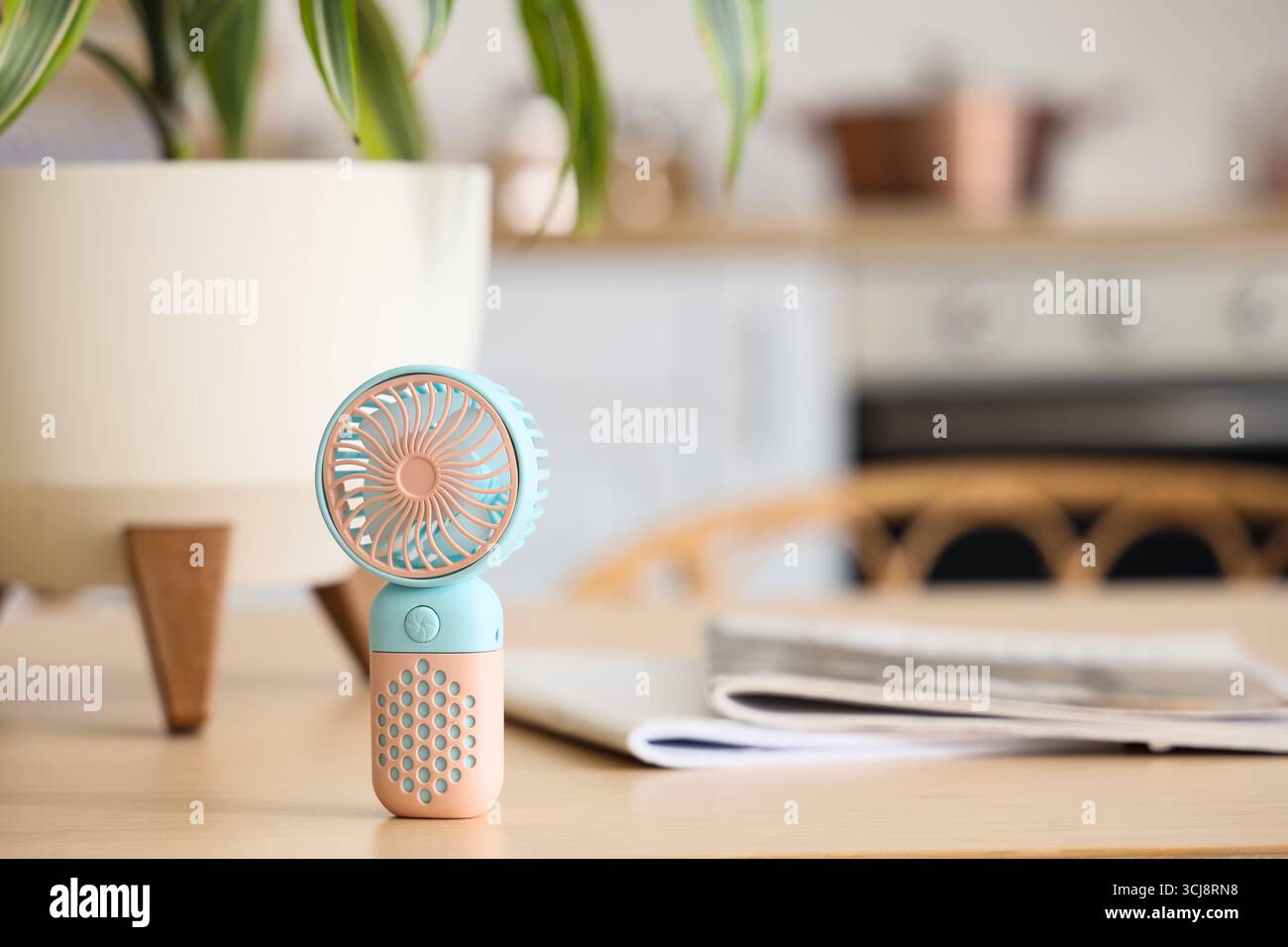 Mini fan on table in kitchen, closeup Stock Photo