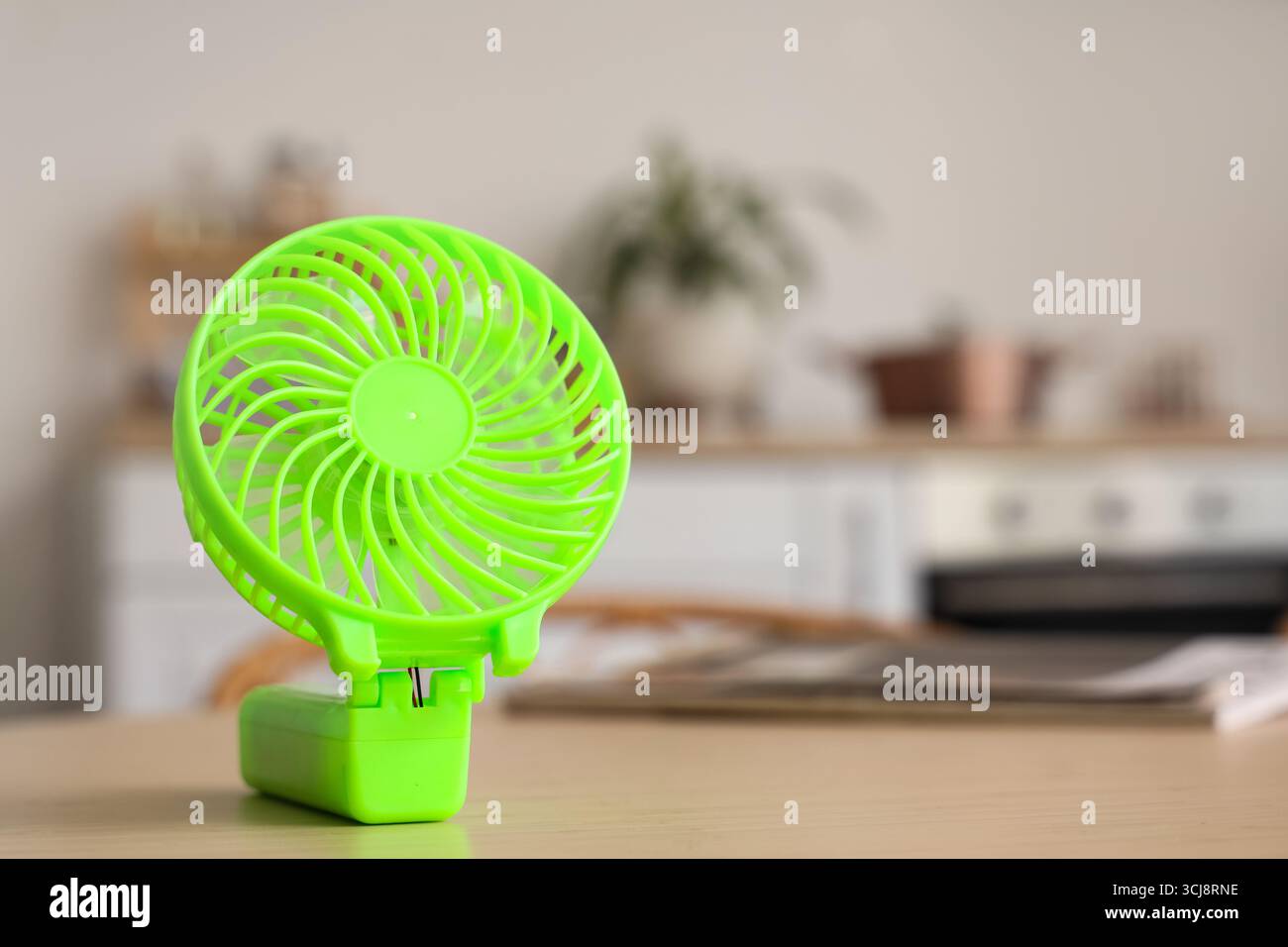 Green mini fan on table in kitchen, closeup Stock Photo