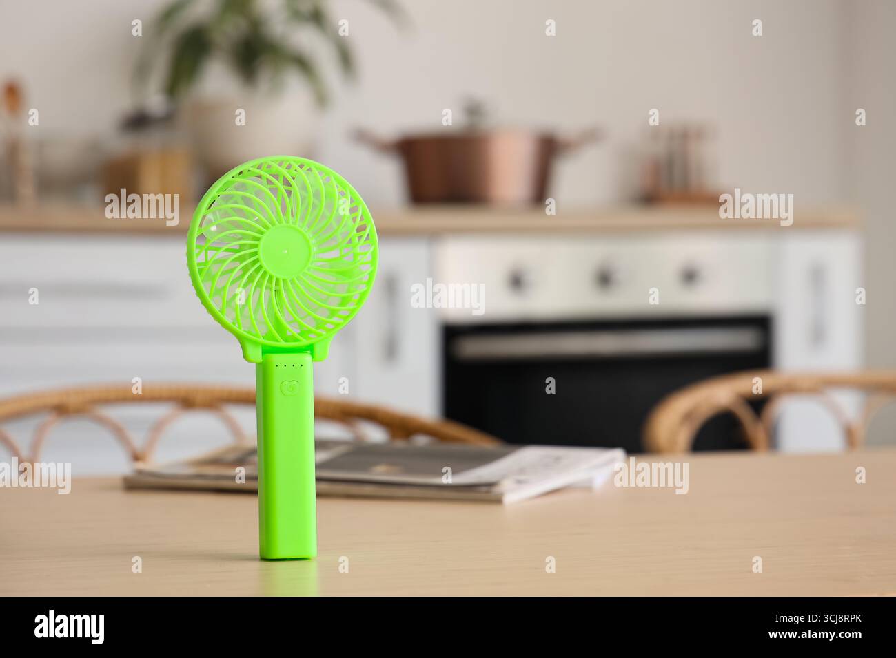 Green mini fan on table in kitchen, closeup Stock Photo
