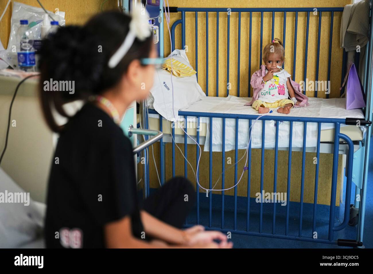 Judi Qudeih, 10, looks at her sister Shamm Qudeih, 2, as Shamm sits on ...