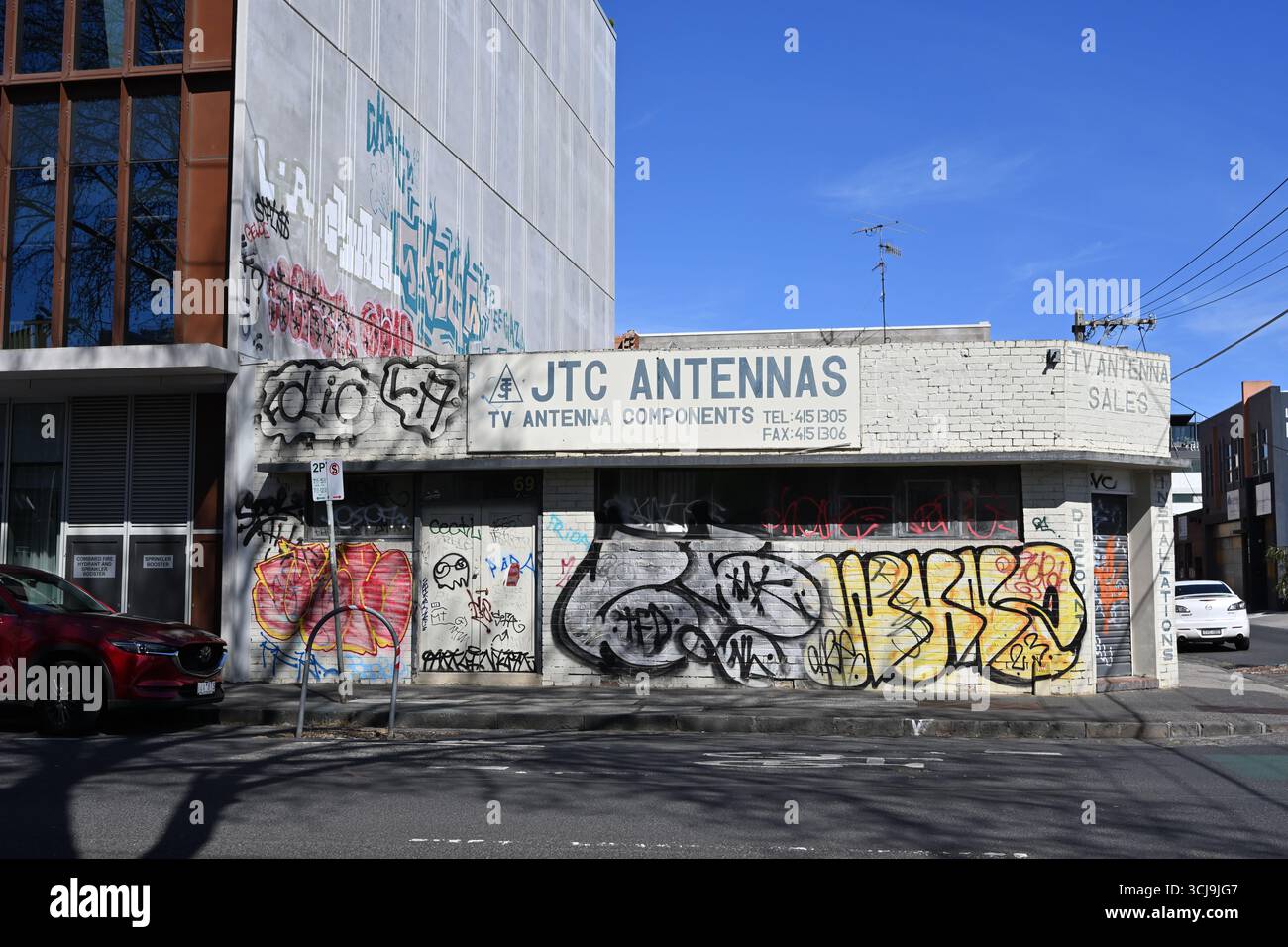 Defaced and graffiti covered exterior of JTC Antennas building in the Melbourne suburb of Collingwood, during a sunny day Stock Photo