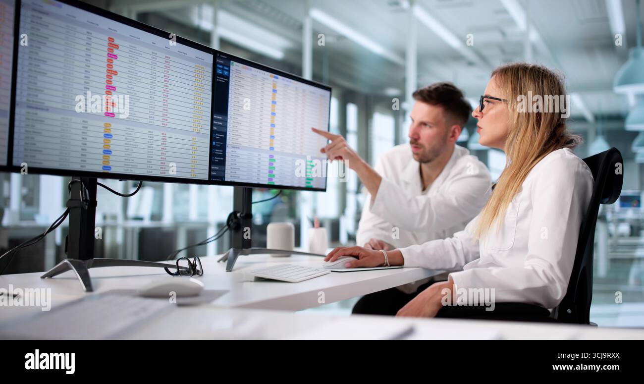Medical Professionals Inputting Billing Codes On Hospital Spreadsheet Documents Stock Photo