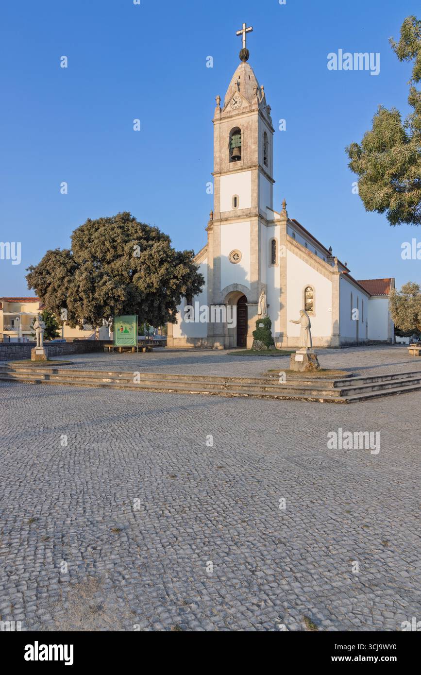 A beautiful view of a church in Fatima, Portugal, with its classic architecture and a prominent bell tower topped with a cross. The peaceful square in Stock Photo