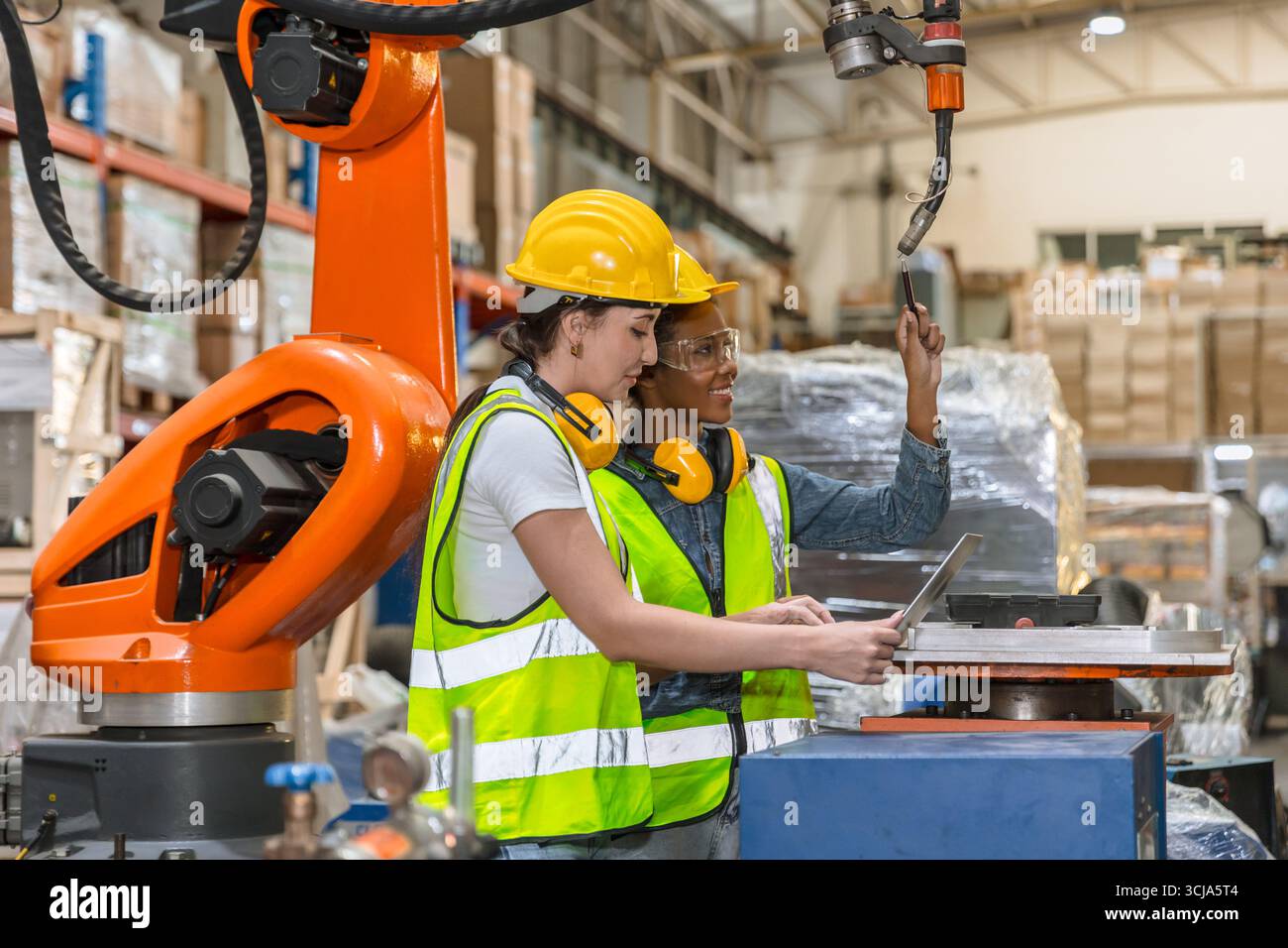 robotic engineer training, technician work in modern factory industrial robot welding arm machine control operator Stock Photo