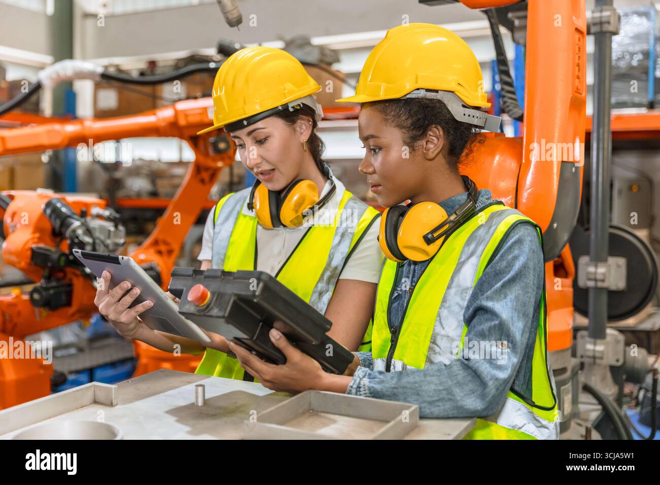 robotic engineer training, technician work in modern factory industrial robot welding arm machine control operator Stock Photo